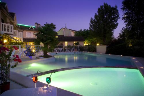 una gran piscina en un patio por la noche en Le Relais de Farrou, en Villefranche-de-Rouergue