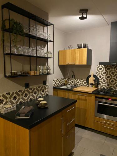 une cuisine avec des placards en bois et un comptoir noir dans l'établissement Huusje18, à Nunspeet