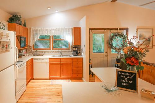a kitchen with wooden cabinets and a white refrigerator at Cozy Whittier Home with Fire Pits Less Than 15 Mi to Hiking! in Whittier