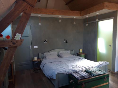 a bedroom with a large bed with white sheets at Studio Nok bij Den Bosch in Den Dungen