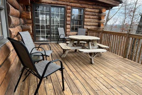 a wooden deck with a picnic table and chairs at Secluded Cabin with Spacious Kitchen and Dining Area! in Sunset