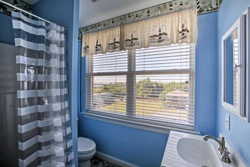 bagno blu con servizi igienici e finestra di New Orleans Waterfront Home with Private Dock! a New Orleans