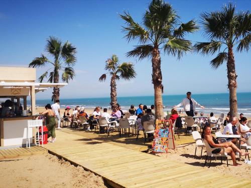 a group of people sitting at tables on the beach at Sunny studio La Mata beach in Torrevieja