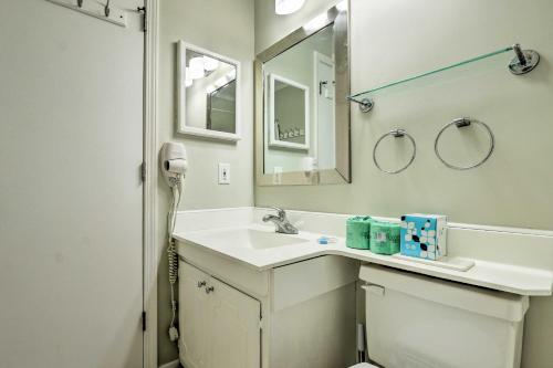 ein weißes Badezimmer mit einem Waschbecken und einem Spiegel in der Unterkunft Resort Condo Pools, Gym, Bar, Beach and More Onsite in Hilton Head Island