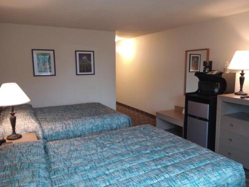 Habitación de hotel con 2 camas y 2 lámparas en Cocusa Motel, en Burlington