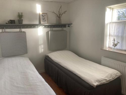a bedroom with two beds and a window at Aasesminde in Fåborg