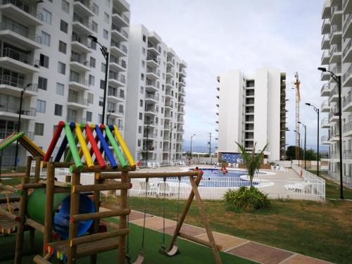 a playground in a apartment complex with tall buildings at Apartamento vista a la montaña in Girardot