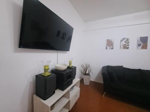 uma sala de estar com uma televisão de ecrã plano na parede em Alojamiento Entero Barrio Agronomia em Buenos Aires