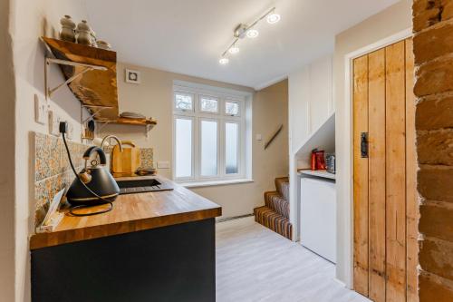 a kitchen with a counter top and a stove top oven at The Doll's House in Holt