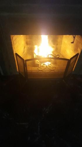 a lit candle in a fireplace in a dark room at Pousada Solar Azul in Miguel Pereira