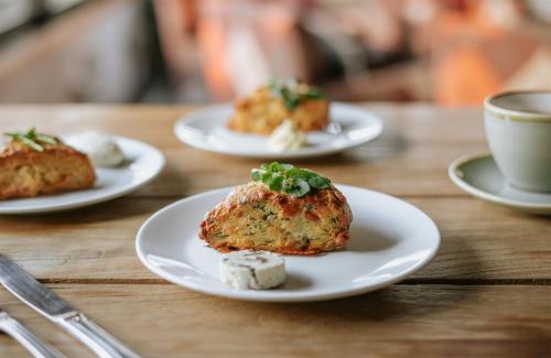 a table with three plates of food and a cup of coffee at Edgewater Hotel in Wanaka