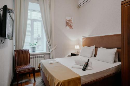 um quarto com uma cama, uma cadeira e uma janela em City Inn Nizami Boutique Hotel em Baku