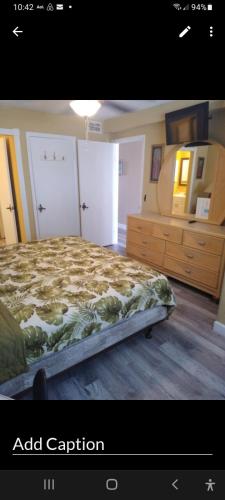 a bedroom with a bed and a dresser and a mirror at The Summit Condo Resort in Panama City Beach