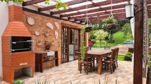 an outdoor patio with a wooden table and a brick oven at Gbsitio in Brasília
