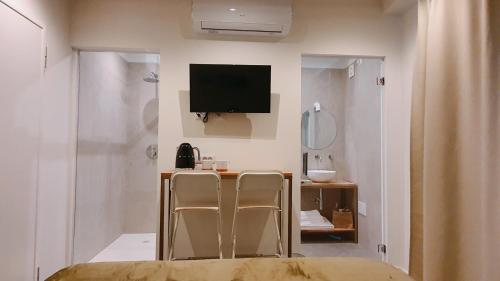 コモにあるFOSCOLO 9 ROOM - BREAKFASTの椅子2脚、デスク、テレビが備わる客室です。