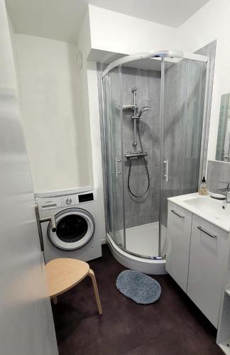 La salle de bains est pourvue d'une douche et d'un lave-linge. dans l'établissement Charmante maison de ville 4 chambres proche de Paris, à Chevilly-Larue