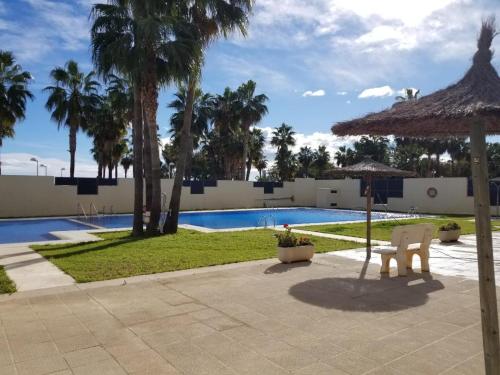 um resort com piscina, guarda-sol e cadeiras em Frontal Las Terrazas 1 en Marina d`Or em Oropesa del Mar