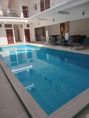 a large swimming pool with blue water at Résidence Marie France MENDY in Toubab Dialaw