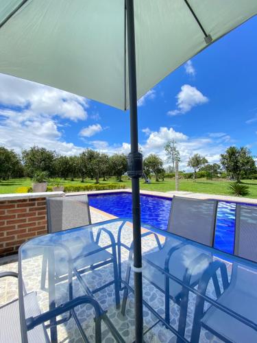 einen Tisch und Stühle unter einem Sonnenschirm auf einer Terrasse in der Unterkunft Private nature surrounded House with Kiosk/Pool. in Riveralta