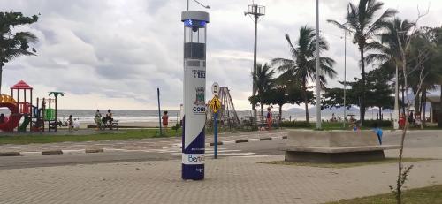a white and blue pole in a park next to the beach at Cristal da Vista Linda Apartamento 03 in Bertioga