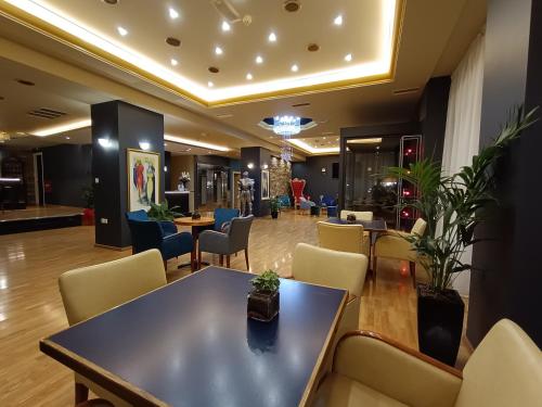 uma sala de espera com uma mesa e cadeiras em Queens Leriotis Hotel em Pireu