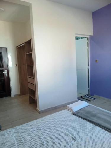 a room with a white wall and a closet at Résidence Marie France MENDY in Toubab Dialaw