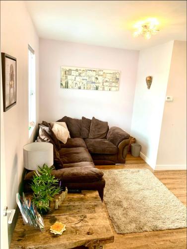 a living room with a brown leather couch at Poppy’s Place in Llandudno Junction