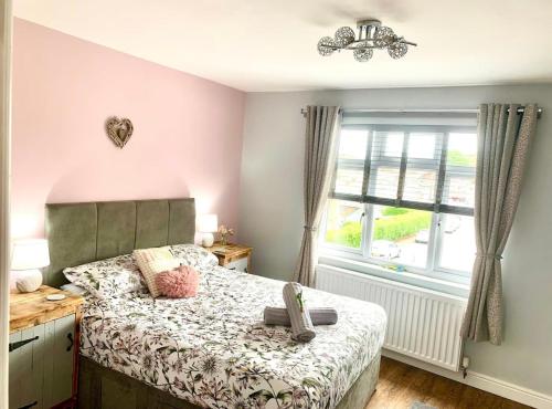 a bedroom with a bed and a window at Poppy’s Place in Llandudno Junction