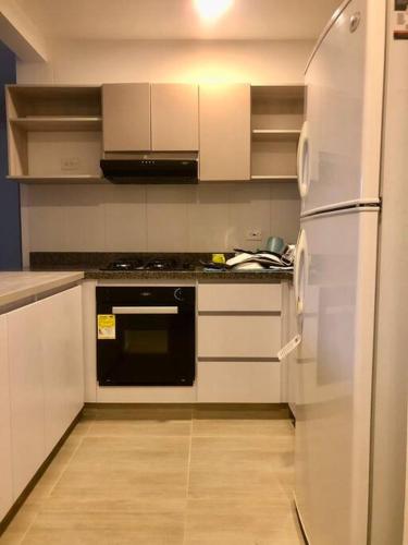 a kitchen with white cabinets and a refrigerator at Apartamento para turismo Villeta - para 7 personas in Villeta