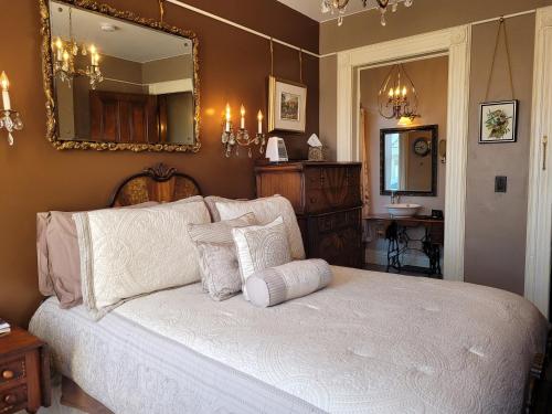 a bedroom with a white bed with a mirror at Buffalo Harmony House in Buffalo