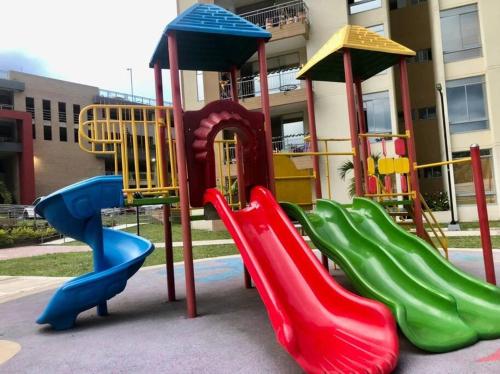 a playground with colorful slides in front of a building at Apartamento para turismo Villeta - para 7 personas in Villeta