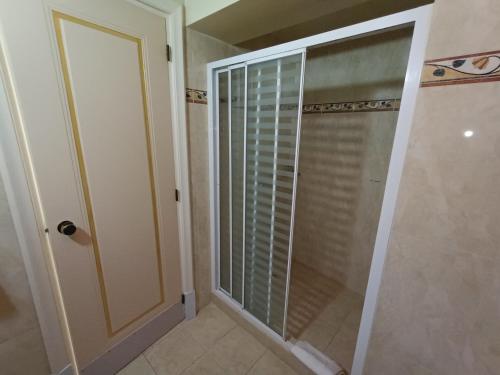a shower with a glass door in a bathroom at Queens Leriotis Hotel in Piraeus
