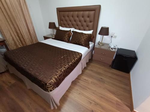 a bedroom with a large bed and two night stands at Queens Leriotis Hotel in Piraeus