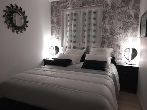 1 dormitorio con 1 cama blanca grande y espejo en Les pieds dans l'eau, en Sainte-Marie-la-Mer