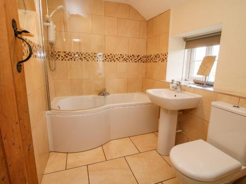 a bathroom with a tub and a toilet and a sink at Little Bicton in Craven Arms