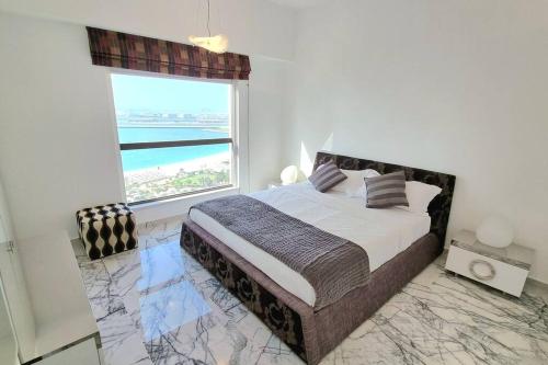 a bedroom with a bed with a view of the ocean at Luxury Sea View Beachfront 3 Bedroom Apt, JBR in Dubai