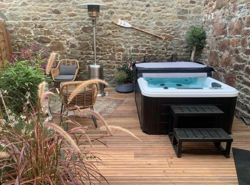 - un bain à remous sur une terrasse avec une table et des chaises dans l'établissement Saint Malo - Jolie Maison avec Jacuzzi 150m gare, à Saint-Malo