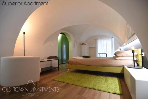 a bedroom with a bed and a green door at Old Town Apartments Catania in Catania