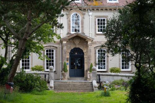 a large house with a blue door and stairs at Fowey Hall Hotel in Fowey