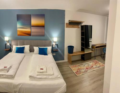 een slaapkamer met een groot wit bed met blauwe muren bij Aparthotel Neumünster City in Neumünster
