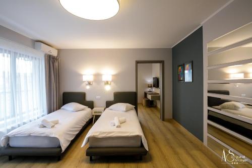 a hotel room with two beds and a mirror at Pensiunea AS in Floreşti