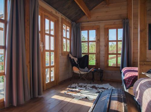 a room with windows and a chair in a wooden house at Pian Del Mund in Borgomale