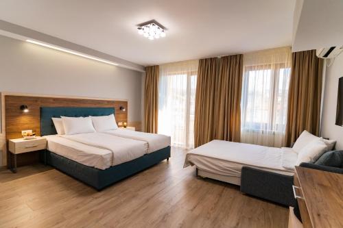 a hotel room with two beds and a couch at Guest House Velik in Sandanski