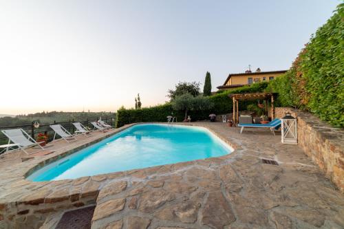 - une piscine dans une cour avec des chaises et des couches dans l'établissement Podere Vergianoni immerso nelChianti con piscina, à Tavarnelle in Val di Pesa