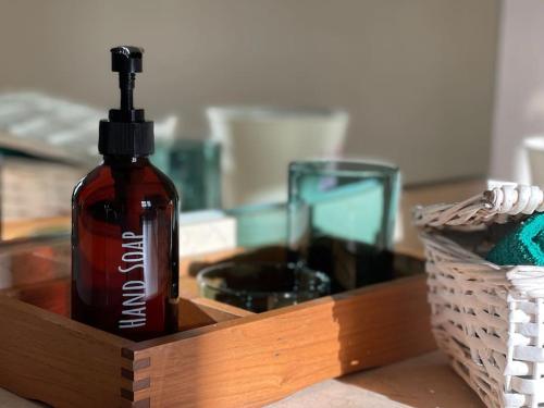 a bottle of alcohol in a wooden box next to a glass at Villa Petronila Tías, LANZAROTE in Conil
