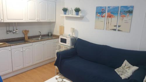 a living room with a blue couch in a kitchen at Ático Berni in Santa Pola