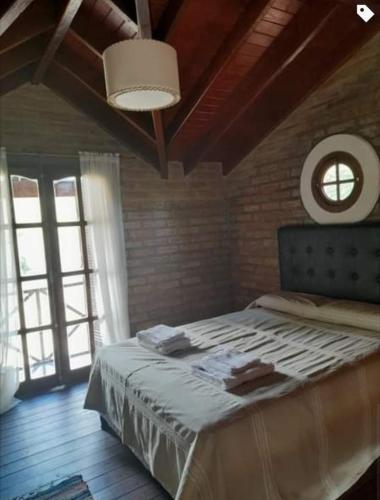 1 dormitorio con 1 cama grande y ventana grande en •JADE• Casas de alquiler en Los Molles