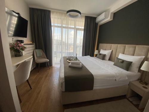Schlafzimmer mit einem Bett, einem Schreibtisch und einem TV in der Unterkunft BW Sky View Belgrade Waterfront in Belgrad