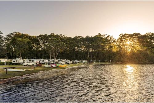 a river with a group of tents in the background at Discovery Parks - Burrill Lake, Ulladulla in Burrill Lake