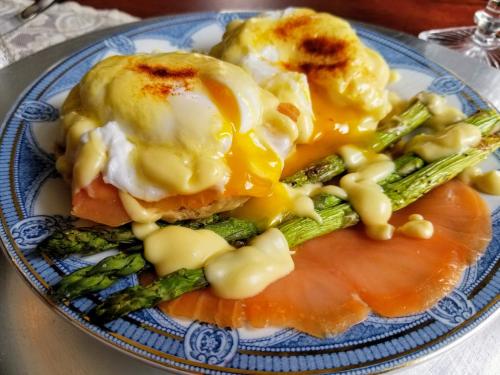 a blue and white plate of food with asparagus and salmon at Buffalo Harmony House in Buffalo